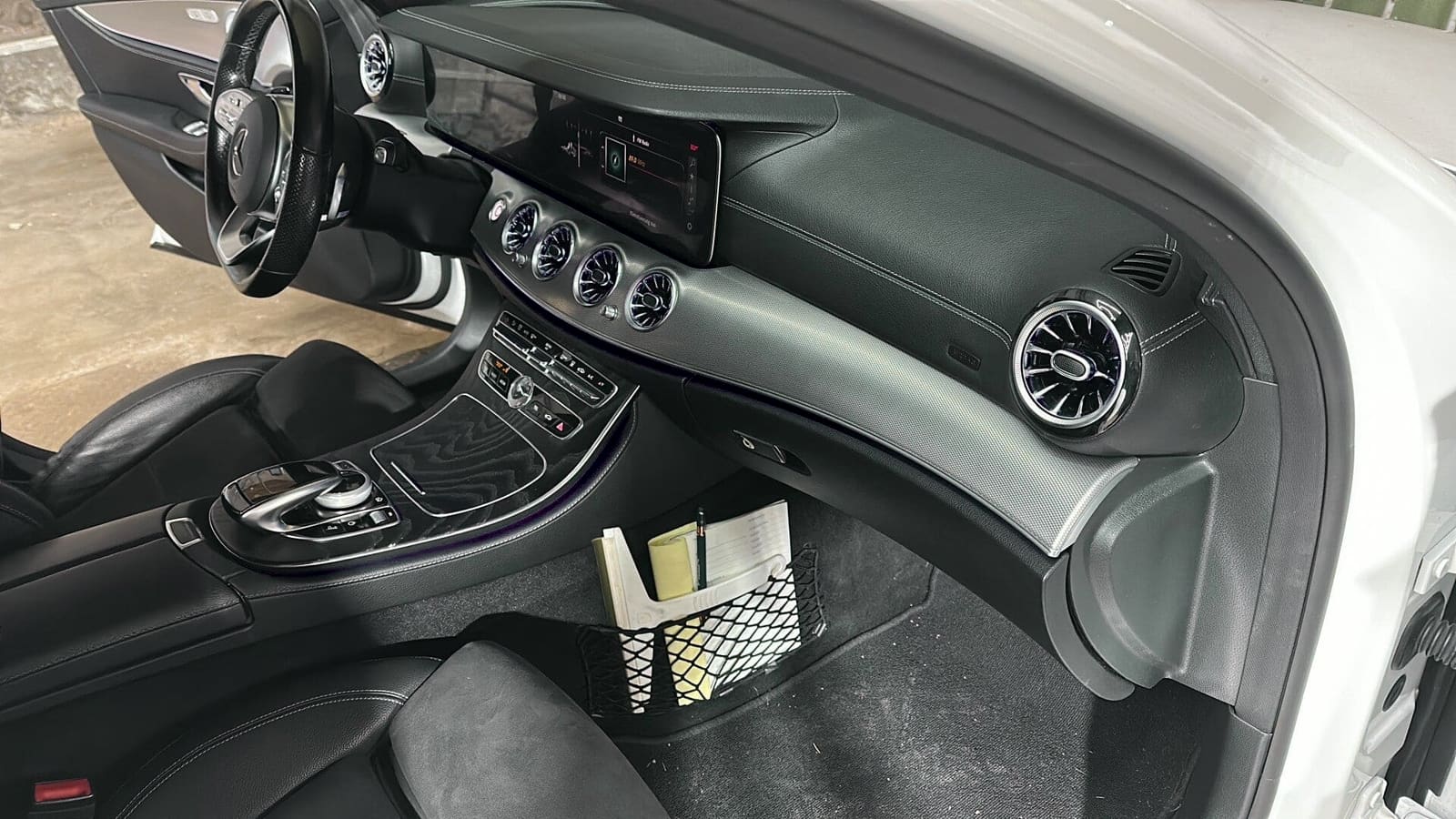 Cockpit eines Mercedes CLS mit Ambientebeleuchtung: Lichtleiste über die ganze Armaturentafel, beleuchtete Turbinendüsen und Lichtkante in der Tür