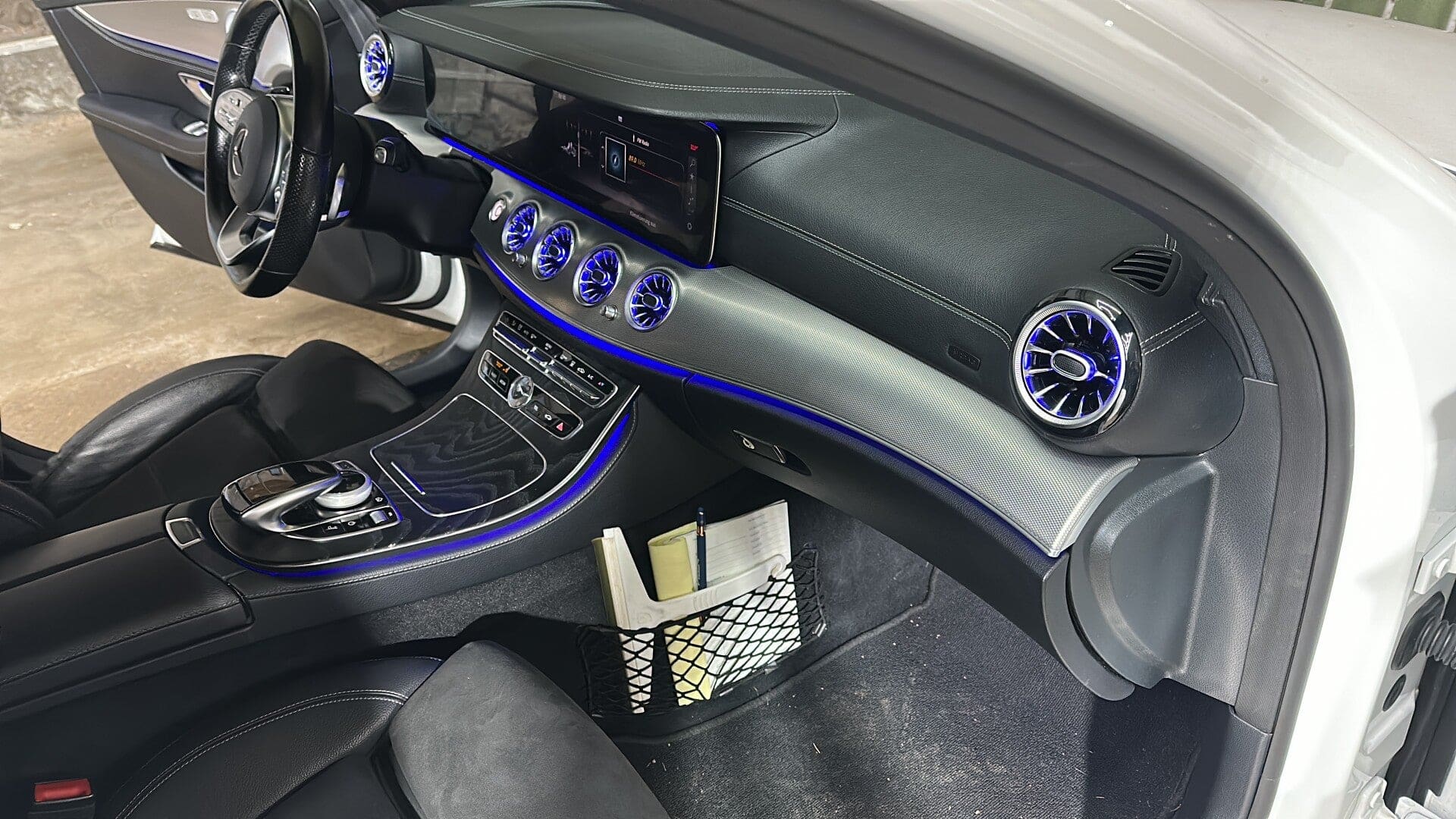 Cockpit eines Mercedes CLS mit blau beleuchteten Turbinen-Lüftungsdüsen und durchgehender Ambiente-Lichtleiste