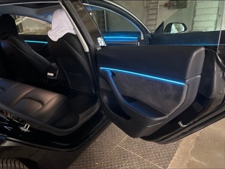 Geöffnete Fahrzeugtür mit eisblau leuchtender Ambiente-Lichtleiste in der Türverkleidung