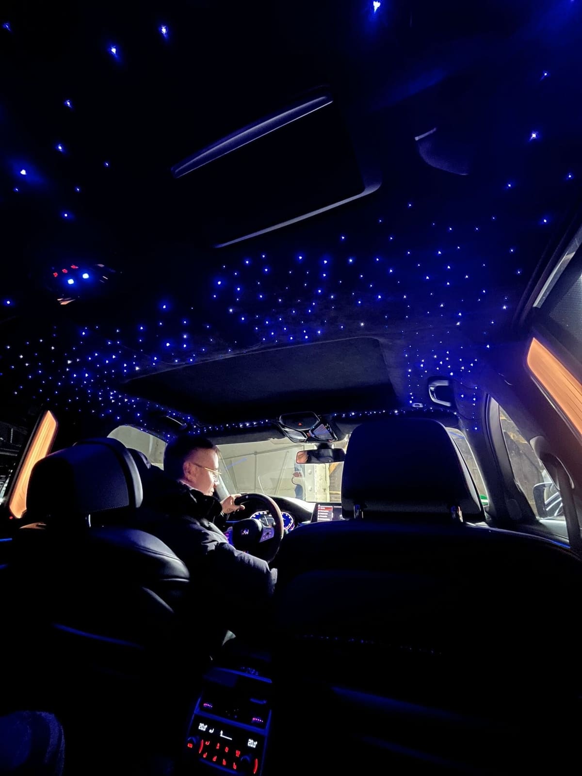 BMW Innenraum bei Nacht: blauer Sternenhimmel im Dachhimmel und warme Ambientebeleuchtung in den Türverkleidungen
