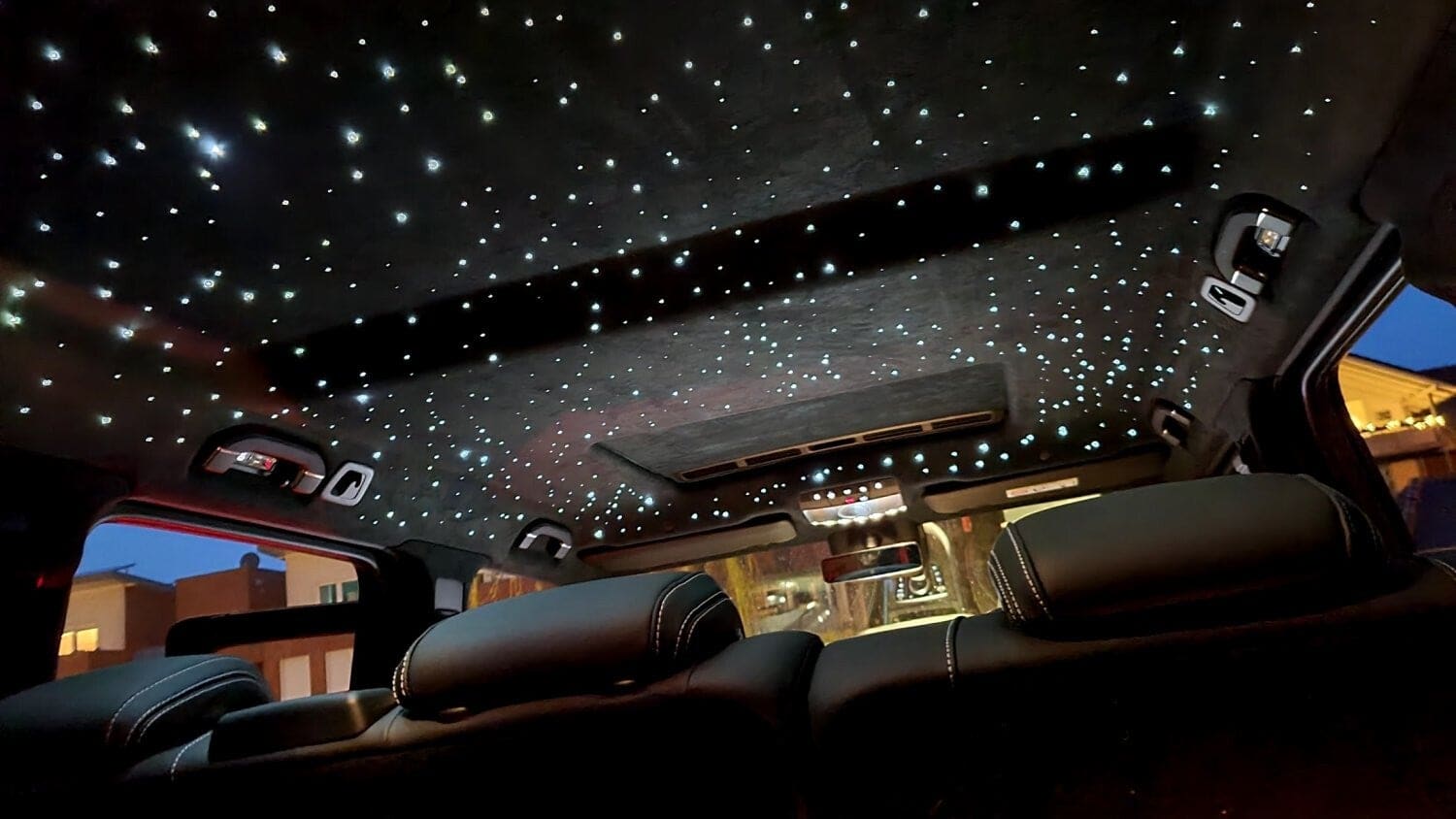 Schwarzer Dachhimmel einer Mercedes E-Klasse mit eingebautem Sternenhimmel – hunderte weiße Lichtpunkte über den Rücksitzen